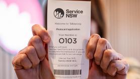 Lady holding up her Service Centre ticket with number